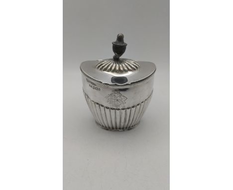 A Victorian silver tea caddy by Atkin Brothers with a fluted body and ebon turned finials, engraved initials and hinged lid, 