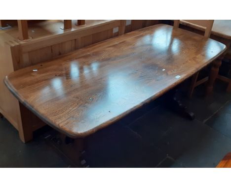 An Ercol dark elm refectory table. 