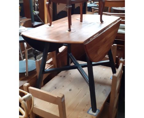 An Ercol elm drop leaf dining table with painted legs. 