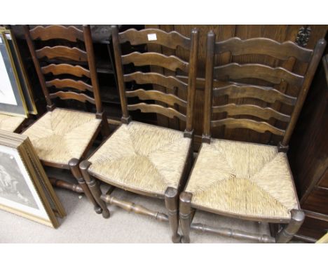A set of six rush seated ladder back chairs including two carvers