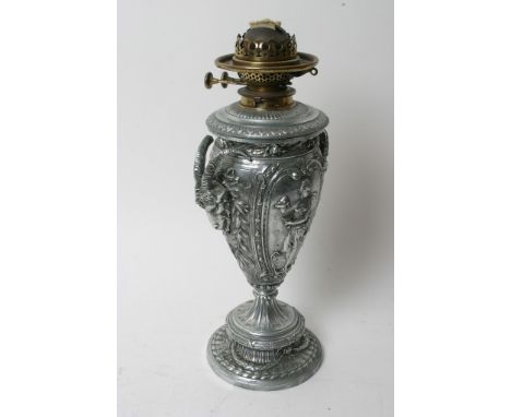 A silver plated oil lamp the sides decorated with raised rams heads