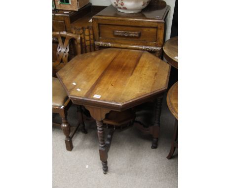 An octagonal topped occasional table with under shelf on caster feet