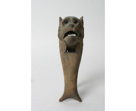 A carved wooden black forest type nutcracker in the form of a Lion's head