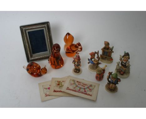 A collection of odds comprising Wedgwood glass paperweights, silver plated photo frame,silk postcards and Goebel figures