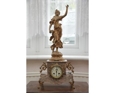 A French gilt spelter and marble mantel clock the marble case surmounted with a female figure