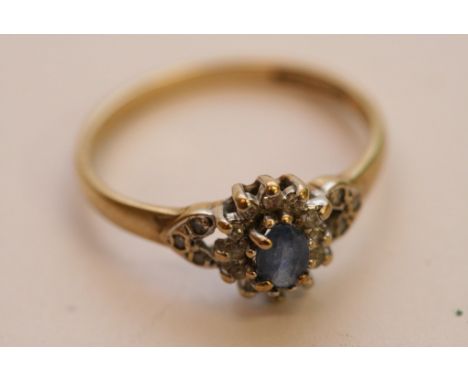 A ladies 9ct yellow gold ring set with a central sapphire with diamond surround