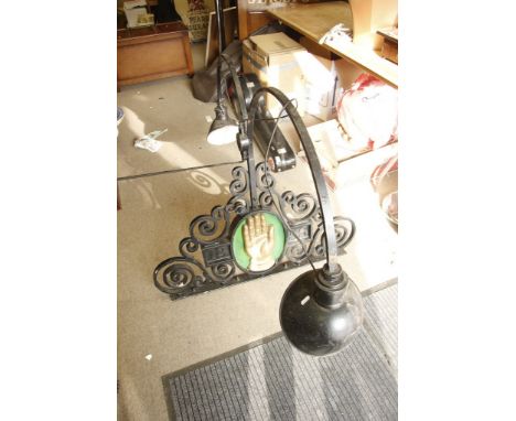 A large wrought iron double armed lamp for mounting above a pub advertising sign