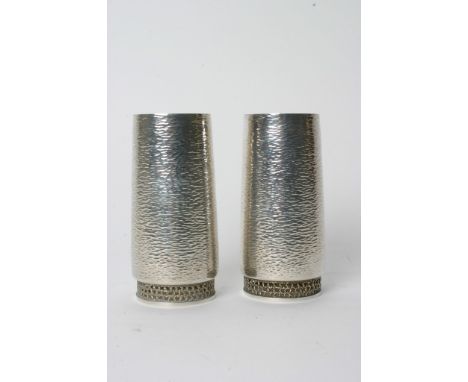 A fine quality pair of Stuart Devlin silver vases of Modernist design having textured surface and pierced gilded bases, beari