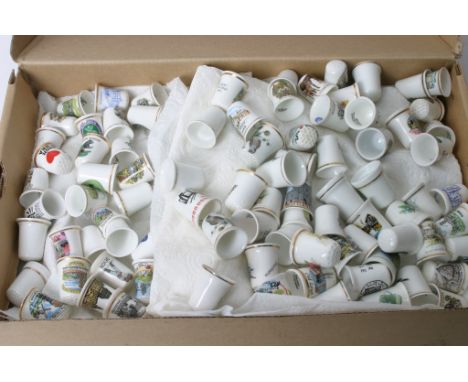 A shoe box containing a collection of ceramic thimbles