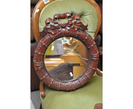 A reproduction Regency style mirror of circular shape with carved surround