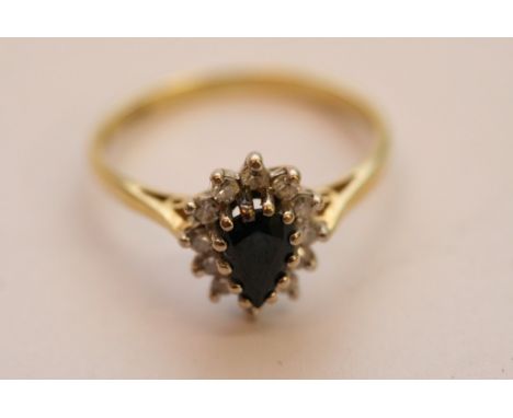 A ladies 9ct gold ring set with pear cut sapphire with diamond surround