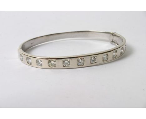 An 18ct white gold hinge opening bangle set with approximately 2.80ct of brilliant cut diamonds in twelve stones