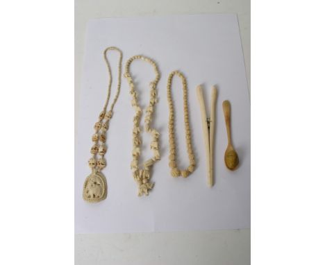 A collection of oddments including ivory and bone comprising necklaces, glove stretchers and other items