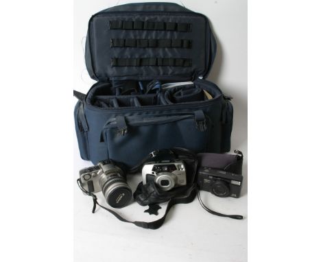A camera bag containing various cameras including Canon 35 mm EOS IX, Pentax Espio 200 