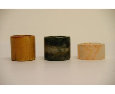 A collection of three Chinese archers thumb rings including bone, agate and one other