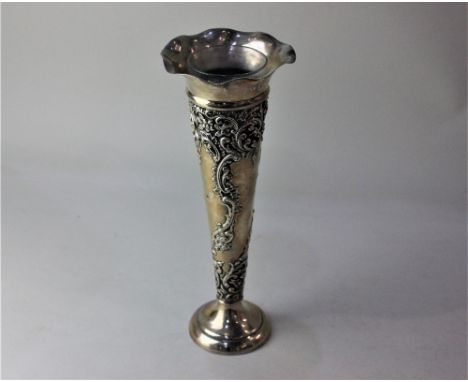 A late Victorian silver trumpet shape vase with embossed scrolls and flowers and circular base, Chester 1899, 5.7oz 26cm