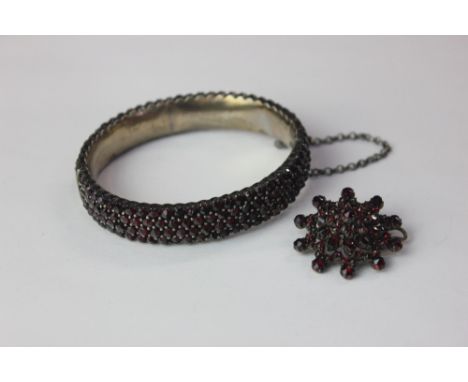 A garnet bangle, hinged, in silver, and a similar brooch