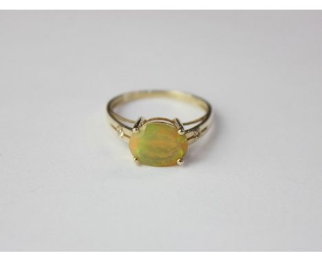 A 9ct gold opal ring with four claw set oval stone 