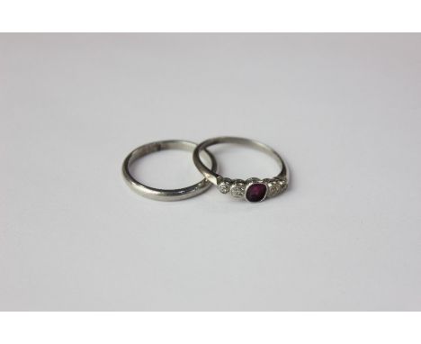 An 18k white gold and platinum ruby and diamond five stone ring with central ruby flanked by two graduating stones and a plat