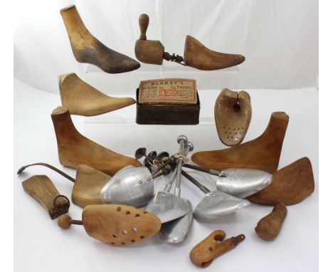 A collection of vintage wooden and metal shoe trees and a vintage tin containing metal segs for shoes to include 'Tom Thumb' 
