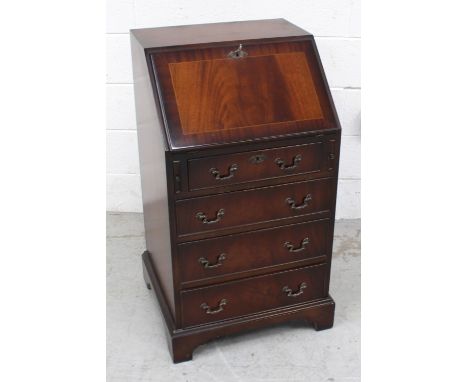 A reproduction mahogany bureau with drop-down desktop to interior pigeonholes, over four drawers to bracket supports, 80 x 50