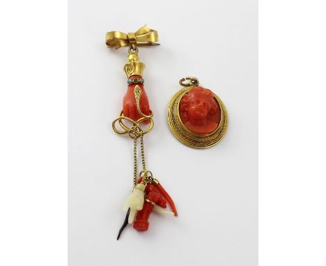 A coral cameo-style pendant in a yellow metal frame and a yellow metal coral and turquoise brooch in the form of a hand suspe