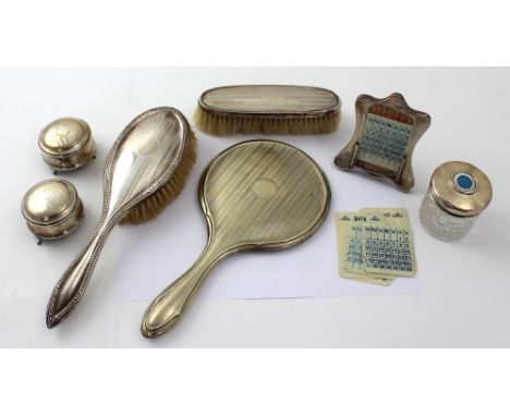 Various hallmarked silver items to include a ladies' and gentlemen's matching hairbrushes, an engine-turned mirror and a pair