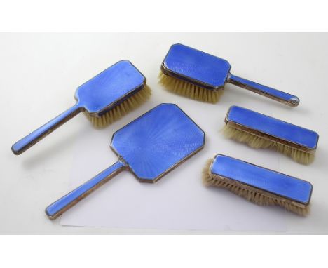 A set of blue enamelled and engine turned hallmarked silver dressing table furniture comprising two clothes brushes, two hand