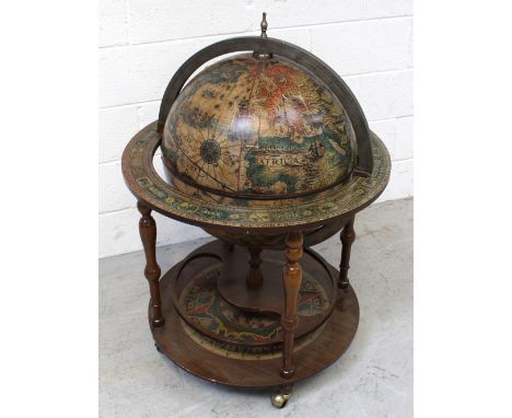 A vintage globe cocktail cabinet, top of globe opening to reveal wooden insert with apertures for bottles, to turned supports