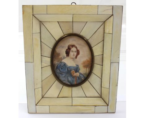 A 19th century portrait miniature, a young lady holding a prayer book, in a piano key frame.