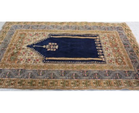 An Eastern-style rug/wall hanging, central blue design of window with a light within concentric floral borders, approx 206 x 