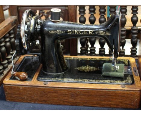 A vintage oak-cased Singer sewing machine. CONDITION REPORT No key present.
