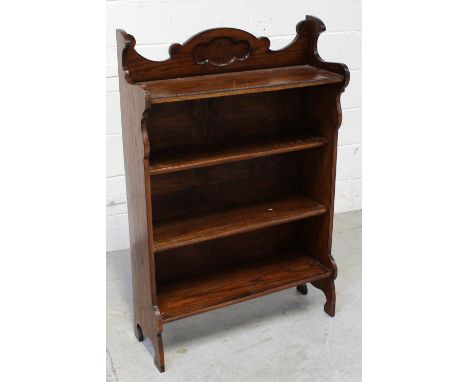 An oak country-style four-shelf bookcase with shaped carved back to bracket supports, height 104cm.