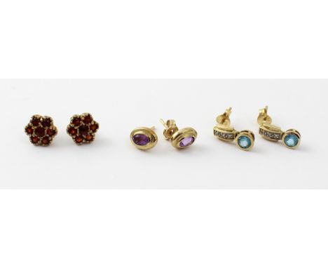 Three pairs of 9ct gold stud earrings, an oval pair set with amethyst, a pair florally set with garnets, and a pair with smal