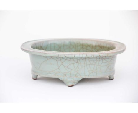 A Chinese celadon jardiniere, 20th century, the flat rim and deep well with a grey/green glaze with wide crackle, resting on 