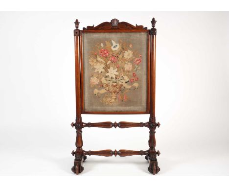 A Victorian mahogany and petit point firescreen, with shell and scroll decoration over turned stretchers on four feet, 102 cm