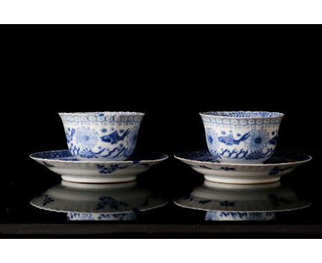 A pair of Chinese, Kangxi blue and white porcelain tea bowls and saucers decorated with carp and Chinese sturgeon, swimming a