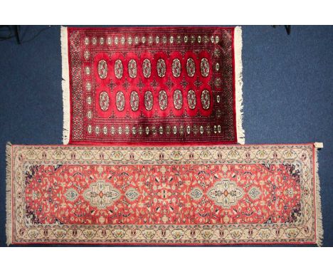 A 20th century Indian carpet runner with cruciform lozenges on a plum red ground within multiple borders. 272cm x 80cm, toget