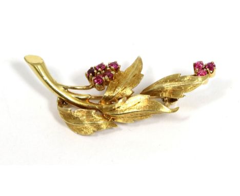 A ruby spray brooch, clusters of round cut rubies to textured leaves, measures 4.3cm by 1.5cm not hallmarked or stamped, valu