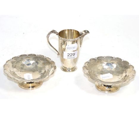 A pair of silver bonbon dishes, Mappin & Webb, Sheffield 1931, with scale decoration; and a silver milk jug, Adie Bros, Birmi