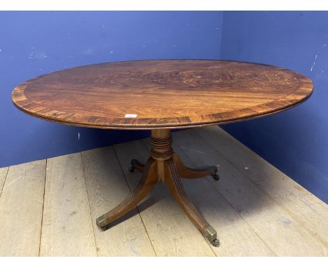 A Regency flame mahogany and line inlaid oval loo table, the central column to swept quadrefoil base, 116 x 130cm 