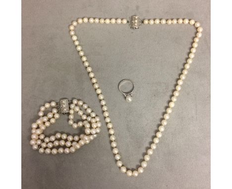 Strand of uniform cultured pearls, and a triple strand of uniform cultured pearls, together with a single pearl ring; 9ct gol