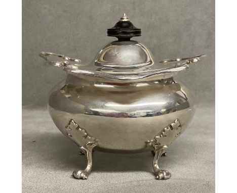 An Edwardian Sterling silver tea caddy raised on for scrolling feet by Goldsmiths and Silversmiths Company Ltd, London, 1905,