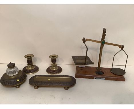 A garniture desk set of glass and brass inkwell, pen tidy, candlesticks, and a weighing scale, all as found 