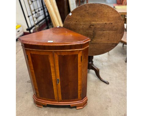 A George III oak circular tripod table and a small yew wood corner cupboard 