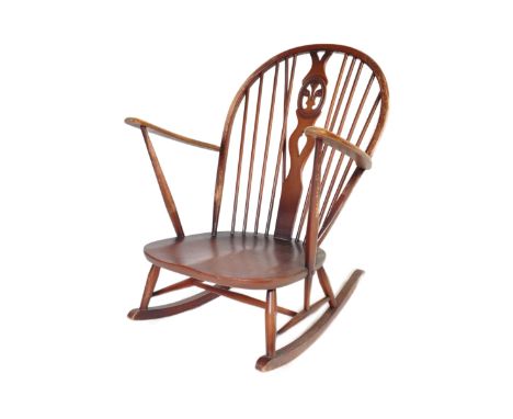 A retro vintage mid 20th Century dark beech and elm rocking chair. With rounded spindle wheelback with straight arms, on curv
