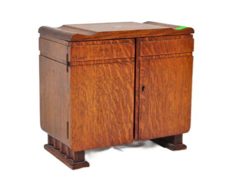 A vintage 20th century circa. 1930's art deco smokers / tobacco cabinet oak cabinet of stepped form. The interior having two 