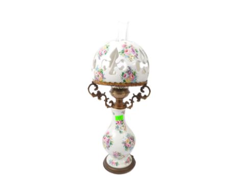 Decorative 20th century table lamp in the form of an oil lamp. Porcelain with chintz foliate sprays to the bulbous body and p