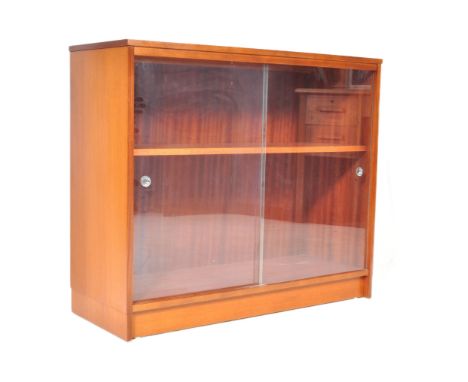 A retro vintage mid 20th Century teak wood cabinet. Of rectangular form with twin sliding glass doors supported on a plinth b