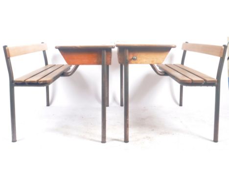 A matching pair of retro vintage mid 20th Century French school desk benches with each comprising of a writing table top with